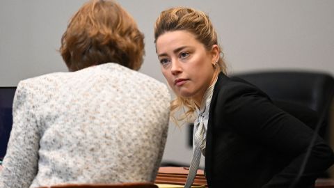 Amber Heard speaks to one of her attorneys at the Fairfax County Circuit Courthouse on April 19.