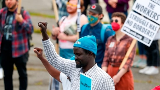 Workers from the Drivers Union raise their fists before the start of the annual May Day March in Seattle.  (AP)