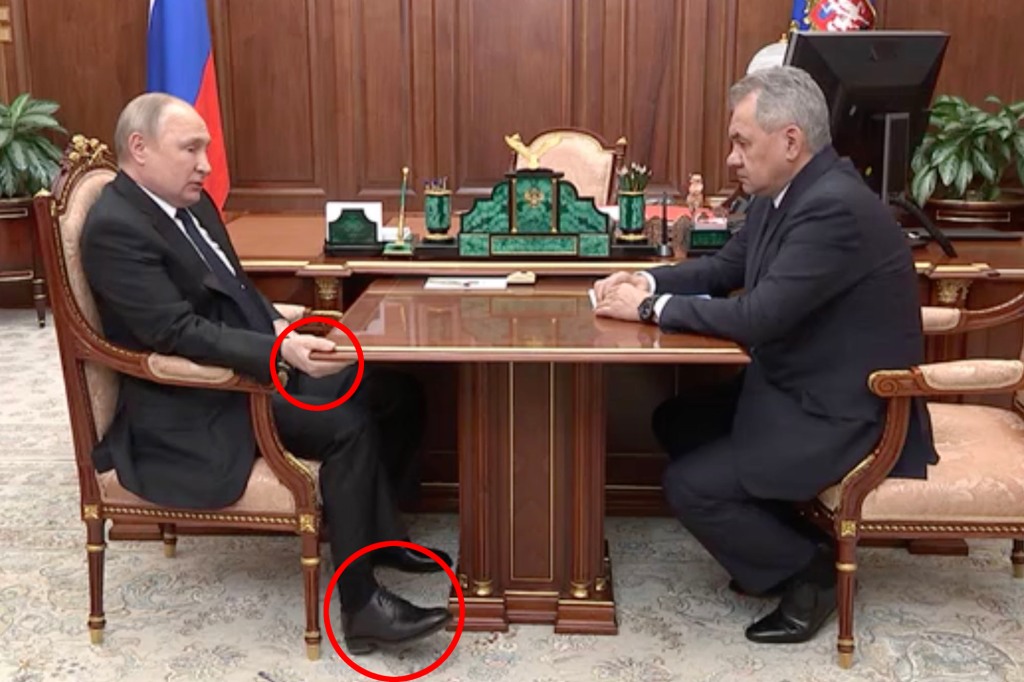 A bloated Vladimir Putin has been seen gripping a table whilst slouching in his chair during a televised meeting with his defense minister amid rumors the Russian strongman is battling cancer.