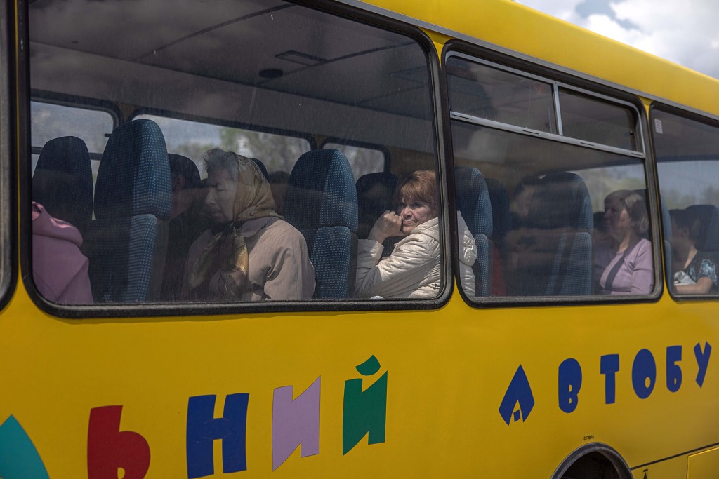 Internally displaced people sit in a bus after arriving from the frontline town of Orikhiv, at the evacuation point in Zaporizhzhia, Ukraine, 02 May 2022
